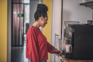 African american girl in profile near coffee machine
